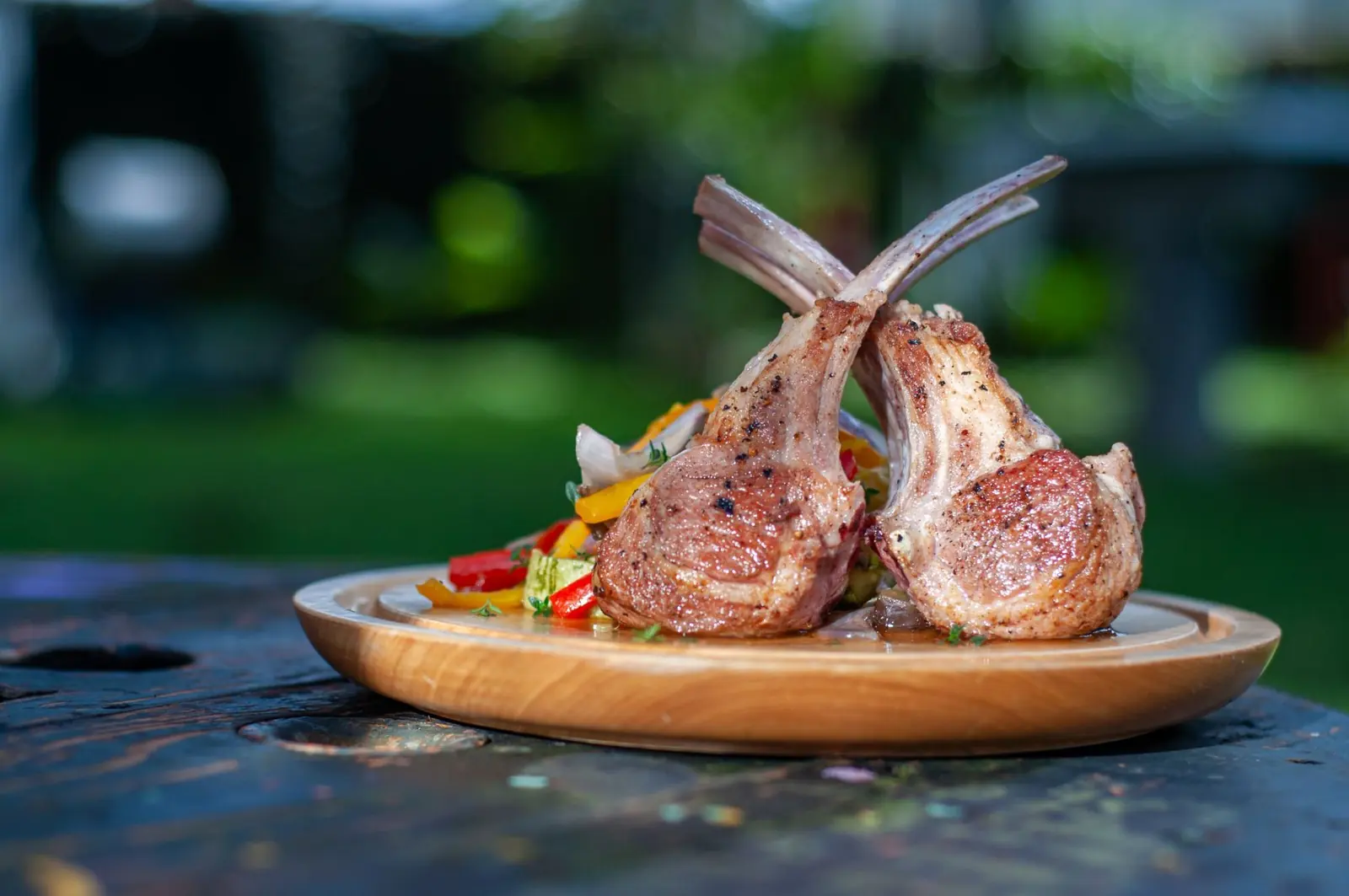 Chuletillas de cordero a la brasa servidas en tabla de madera