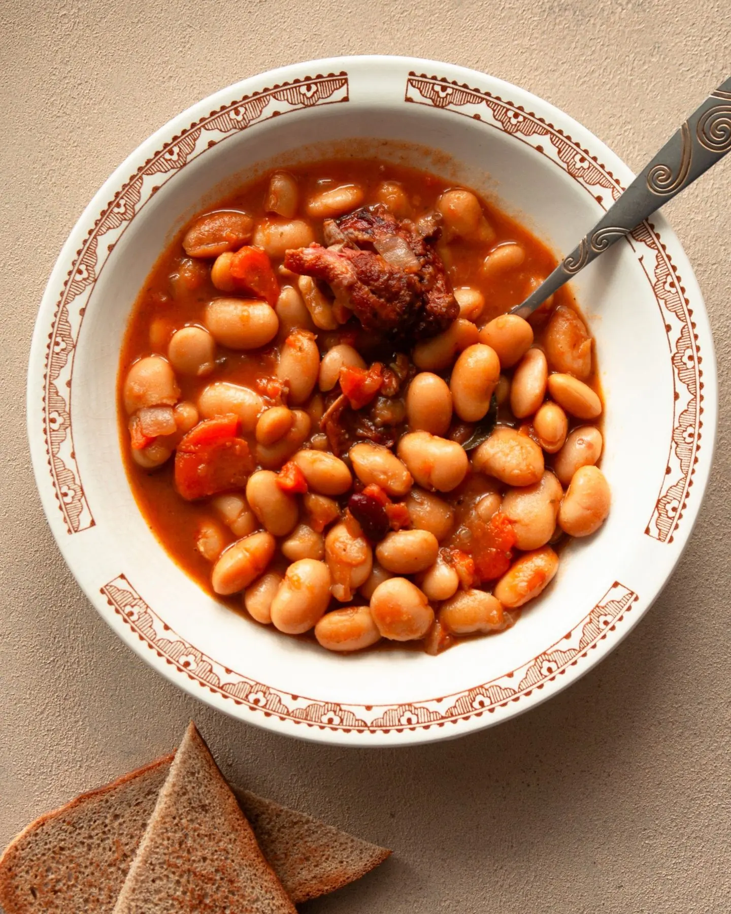Plato de judiones guisados con su caldo y trozos de carne